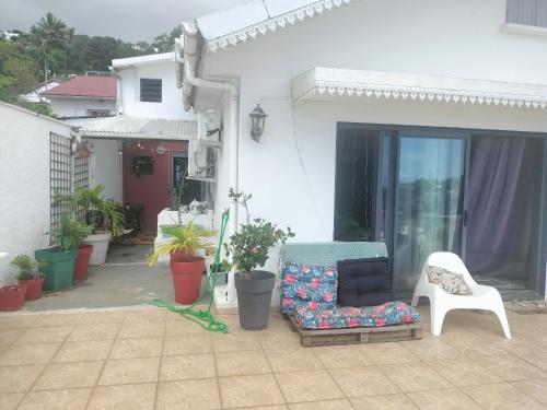 a patio with a couch and a chair and some plants at KAZANNa in Sainte-Clotilde