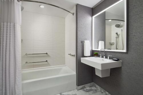 a bathroom with a sink and a tub and a toilet and a mirror at Grand Hyatt Washington in Washington