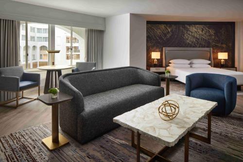 a hotel room with a bed and a couch and chairs at Grand Hyatt Washington in Washington