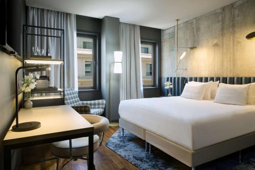 a hotel room with a large bed and a desk at NH Collection Buenos Aires Jousten in Buenos Aires