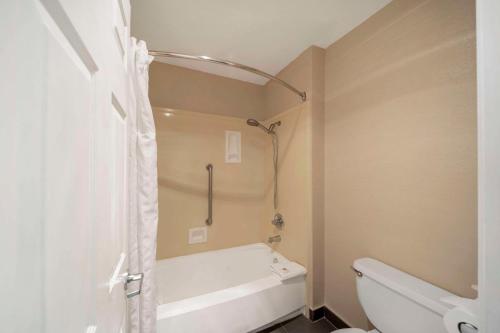 a bathroom with a white tub and a toilet at Comfort Suites Red Bluff near I-5 in Red Bluff