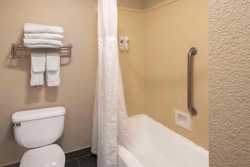 a bathroom with a toilet and a shower with towels at Comfort Suites Red Bluff near I-5 in Red Bluff