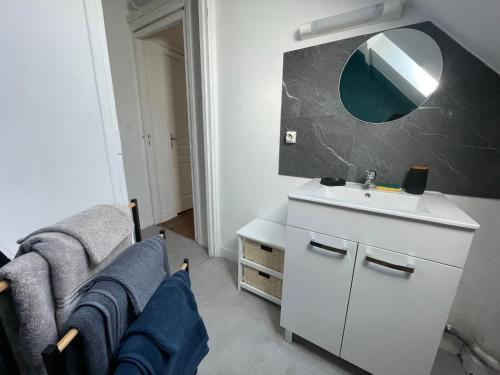 une salle de bain blanche avec un lavabo et un miroir dans l'établissement LES PINS - 24 Heures du Mans, au Mans