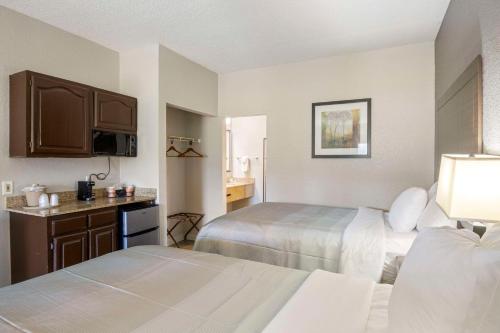 a hotel room with two beds and a kitchen at Quality Suites Hickory South in Hickory
