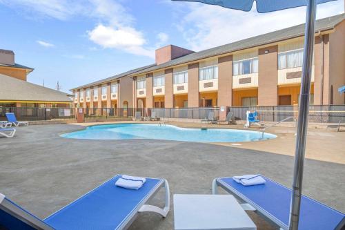 a hotel with a pool in front of a building at Quality Suites Hickory South in Hickory