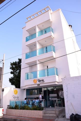a white building with a man standing in front of it at Karin Hotel in Ríohacha