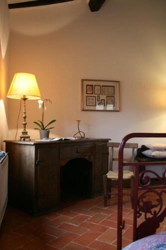 a room with a desk with a lamp and a table at Podere Marella in I Pieracci