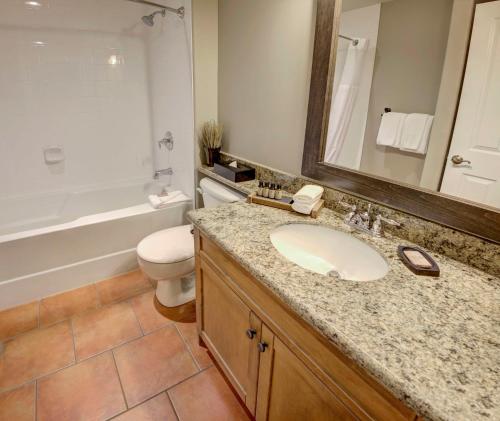 a bathroom with a sink and a toilet and a mirror at Spirit Ridge, in The Unbound Collection by Hyatt in Osoyoos