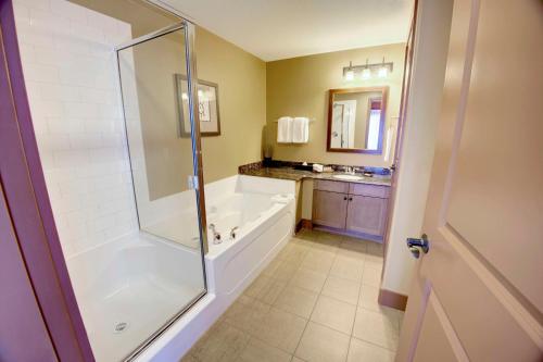 a bathroom with a shower and a tub and a sink at Spirit Ridge, in The Unbound Collection by Hyatt in Osoyoos