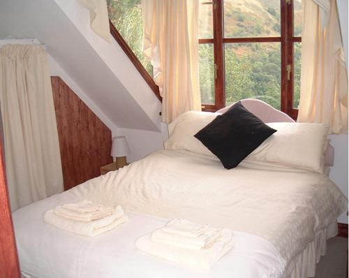 Un pat sau paturi într-o cameră la Horseshoe Pass Holiday Lets