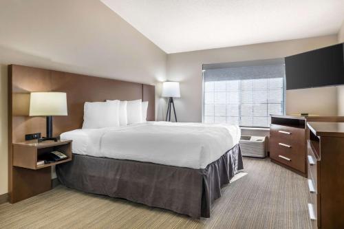 Una habitación de hotel con una cama grande y una ventana. en Country Inn & Suites by Radisson, Watertown, SD, en Watertown