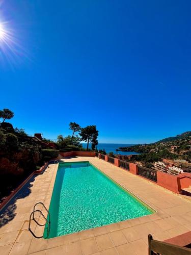 une piscine avec vue sur l'océan dans l'établissement Duplex vue mer dans résidence avec piscine et parking, à Théoule-sur-Mer