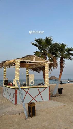 a lifeguard station on the beach with a palm tree at HDB Al Khobar Resort & Spa in Al Khobar