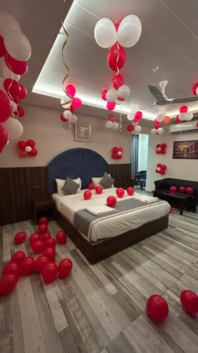 a bedroom with a bed with red and white balloons at Raksha Suites & Banquet Greater Noida in Greater Noida