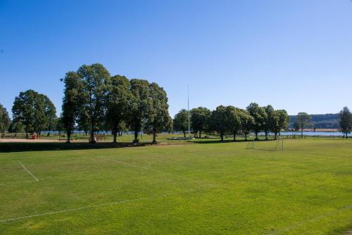 a large grass field with trees in the background at Hotel Hehrne Kök & Konferens in Vänersborg