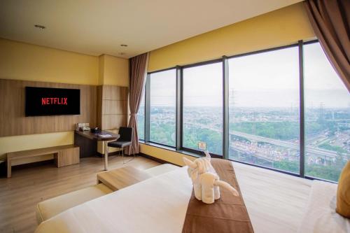a hotel room with a bed and a large window at Vasaka Hotel Jakarta Managed by Dafam in Jakarta