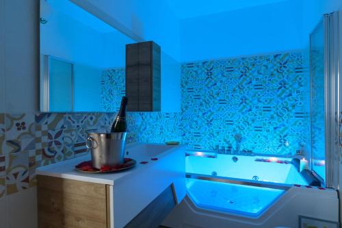 a bathroom with a tub with a blue light at La MaGia del Tramonto in Salerno