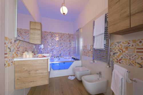 a bathroom with a tub and a toilet and a sink at La MaGia del Tramonto in Salerno