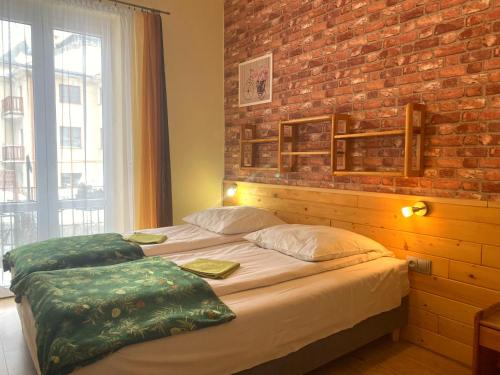 a bedroom with two beds with a brick wall at Dom Wypoczynkowy ADRIA in Krynica Zdrój