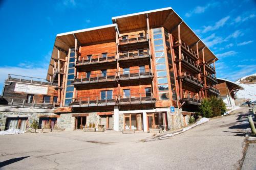 a large building in the middle of a parking lot at Les Myrtilles in Chamrousse