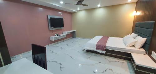 a bedroom with a marble floor with a bed and a tv at SC Hotel in Bacha
