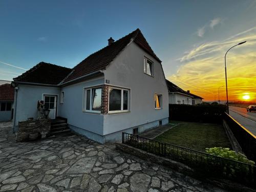 a white house with the sunset in the background at Gemütliches Einfamilienhaus mit Garten in Gemeinlebarn