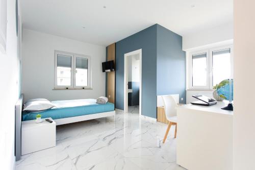 a bedroom with a blue bed and a desk at Alba Affittacamere in Tito