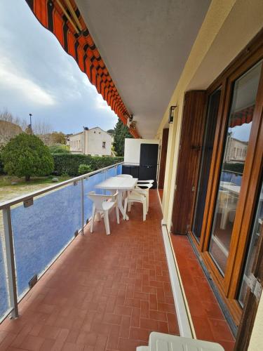 un patio avec une table et des chaises sur un balcon dans l'établissement Beau T2 - ST Clair Le Lavandou, au Lavandou