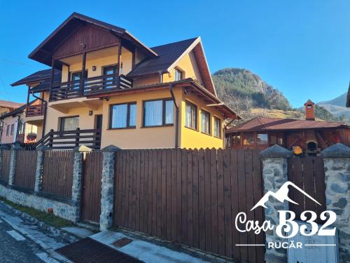a house with a fence in front of it at Casa B32 Spa Rucar in Rucăr
