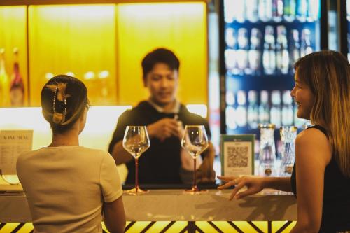 two women standing at a bar talking to a bartender at Chiangkhan River Mountain Resort in Chiang Khan