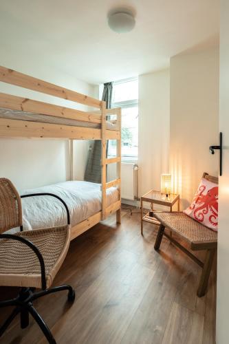 a bedroom with a bunk bed and a chair at Beautiful Beach Holiday Home with Sauna and Garden in Wijk aan Zee