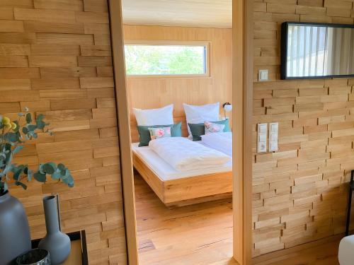 a bedroom with a bed in a wooden wall at Beim Dorfbach - Die Hofchalets in Kressbronn am Bodensee