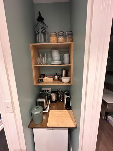 a kitchen with a counter and a shelf with dishes at Two Rivers Ohakune - Boutique Bed and Breakfast in Ohakune