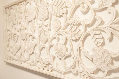 a white wall with a floral design on it at Beim Dorfbach - Die Hofchalets in Kressbronn am Bodensee