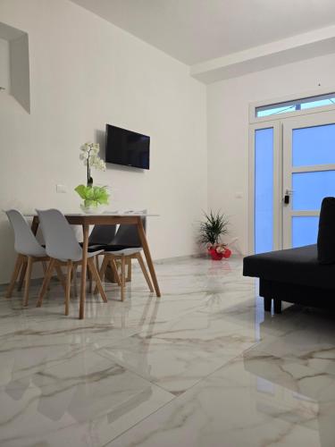 a living room with a table and chairs and a television at Casa MaDo in Pisa