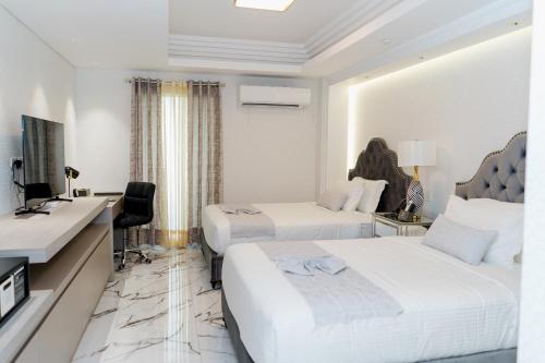 a hotel room with two beds and a desk at The Residence by Ivory in Iligan City
