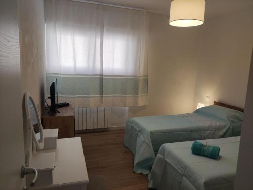 a hotel room with two beds and a television at Holiday Rooms in Santa Teresa in Santa Teresa Gallura