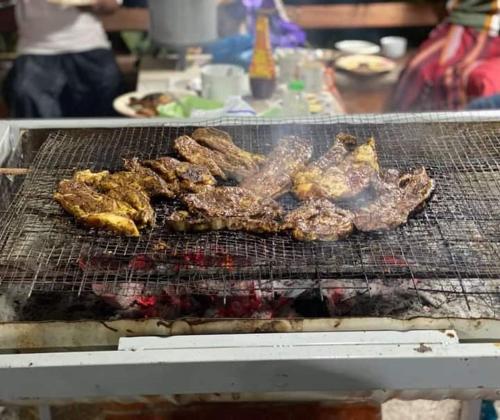 a grill with meat and other food on it at Villa Mas GentingMuslim Homestay in Yan
