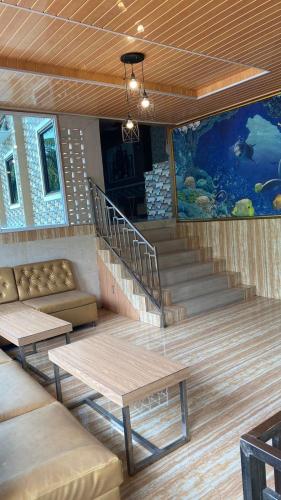 a room with a staircase and a couch and tables at NSO Hotel in Metro