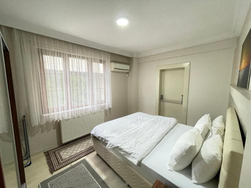 une chambre avec un lit blanc et une fenêtre dans l'établissement Apart Point, à Istanbul