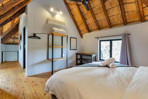 a bedroom with a large white bed and a window at The Bush House in Hoedspruit
