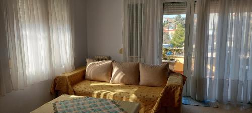 a living room with a couch and a window at Billy's apartments in Artemida