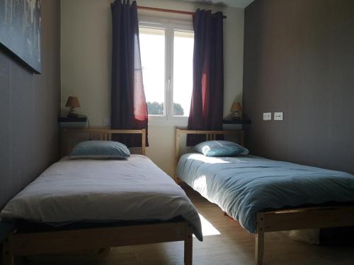 deux lits dans une chambre avec une fenêtre dans l'établissement Terre de Grès & Maison de vacance, à Gueutteville-les-Grès