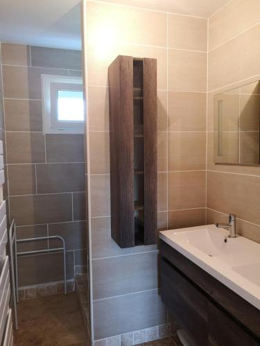 une salle de bain avec un lavabo et un miroir dans l'établissement Terre de Grès & Maison de vacance, à Gueutteville-les-Grès