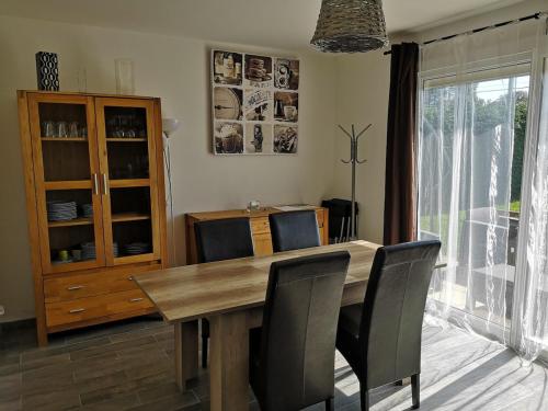 une salle à manger avec une table et des chaises en bois dans l'établissement Terre de Grès & Maison de vacance, à Gueutteville-les-Grès