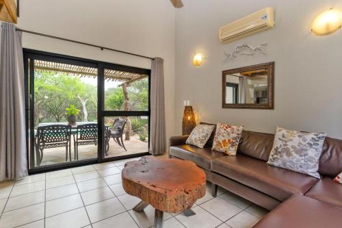 a living room with a couch and a table at The Bush House in Hoedspruit