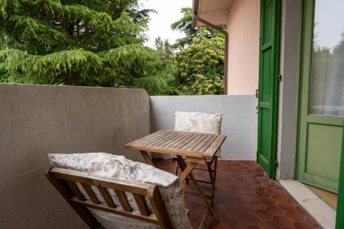 a wooden table and chairs on a porch with a green door at Tana del Cinghiale in Tirli