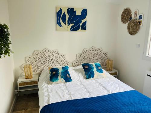 a bedroom with a blue and white bed with blue pillows at Maison Isal in Roquebrune-sur-Argens