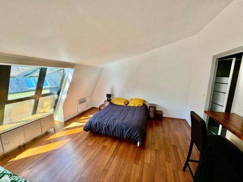 une chambre avec un lit avec des oreillers jaunes dessus dans l'établissement Grand studio a 2 pas du vieux port, quartier Gabut, à La Rochelle