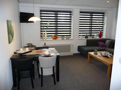 a kitchen and living room with a table and chairs at Apartment Nieuw-Moscou in Hollandscheveld